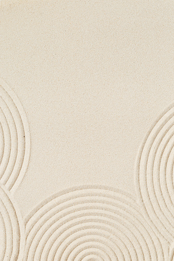 Pattern in Japanese Zen Garden with concentric circles on sand for meditation and tranquility. Aesthetic minimal sandy background. Top view.