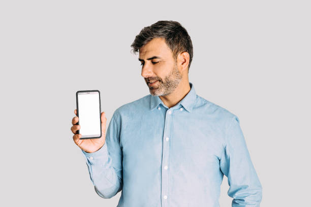 istock Man holding and looking at smart phone with mockup on white background 1364917536