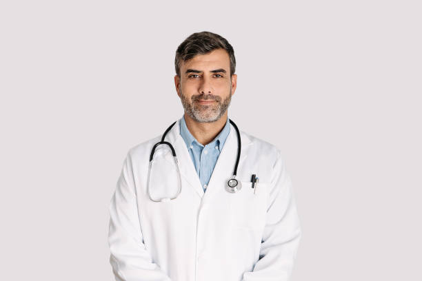 istock Handsome doctor smiling and standing on white background 1364917551