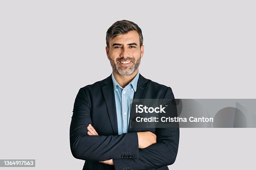 istock Businessman smiling with arms crossed on white background 1364917563