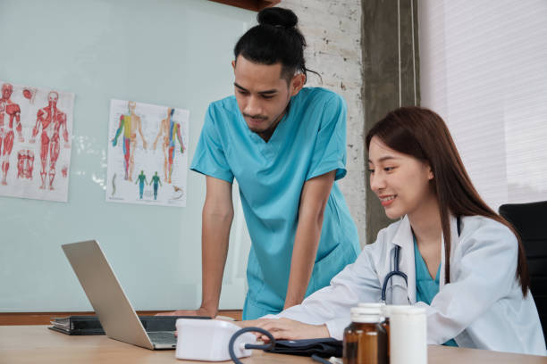 istock Two uniformed young doctors work in medical clinic office. 1364919694