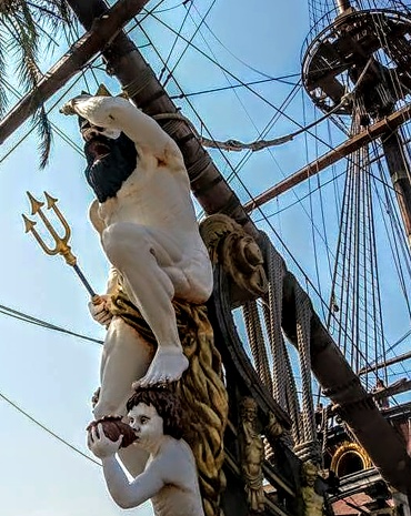 Neptune with Trident statue on the ship docked at the dock