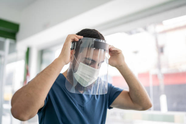 istock Nurse putting on face shield at vaccination center 1364925001