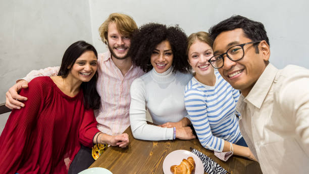 istock smiling friends taking a selfie during breakfast, multiracial university Erasmus group in a moment of relaxation, coffee shop activities with young students 1364925444