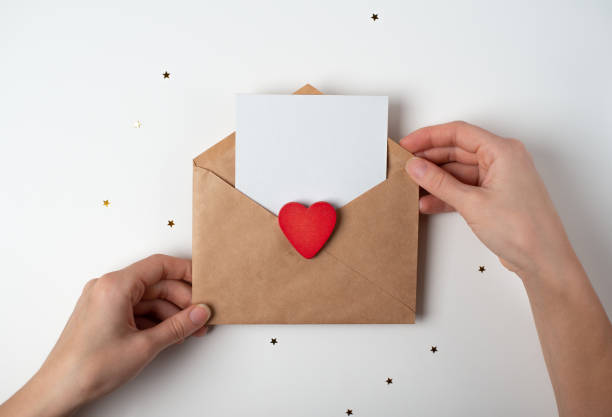 istock Woman's hands holding a blank sheet of paper in craft envelope. 1364930116