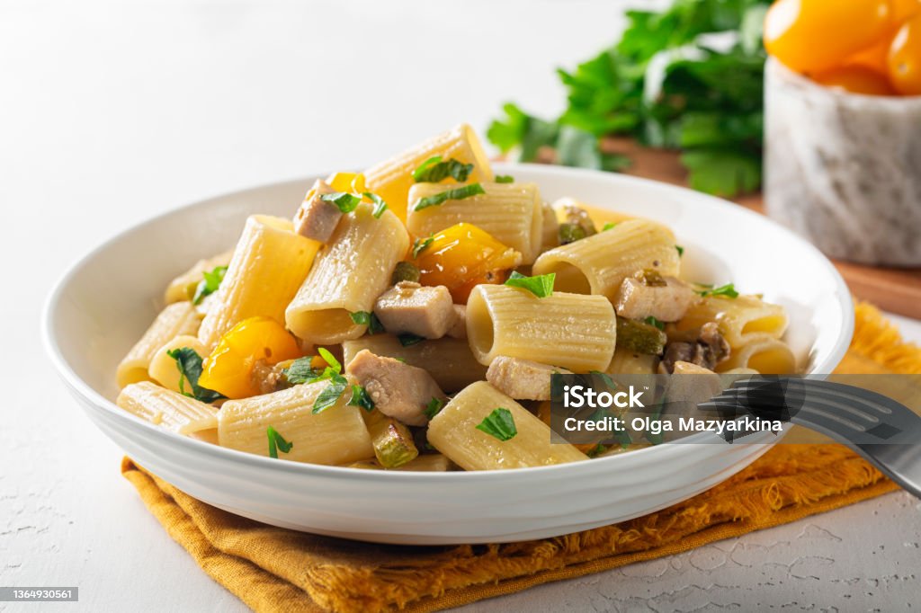 Paccheri Pasta With Swordfish, Cherry Yellow Tomato and zucchini. Close up. Paccheri Stock Photo