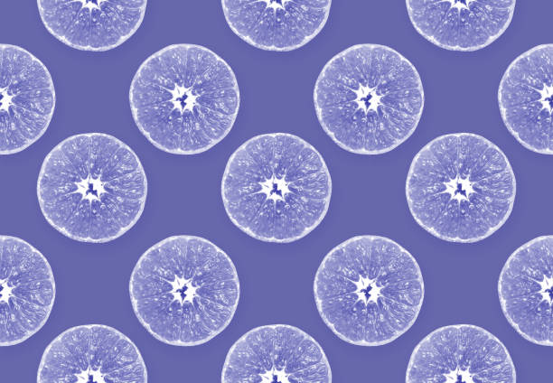 Design background from pieces of orange or tangerine in color Very Peri. Seamless fruit pattern in trendy color of Very Peri. Concept of 2022