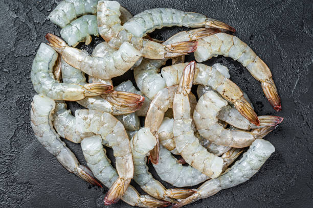 istock Fresh raw black shrimps prawns on a stone Board. Black background. Top view 1364932544