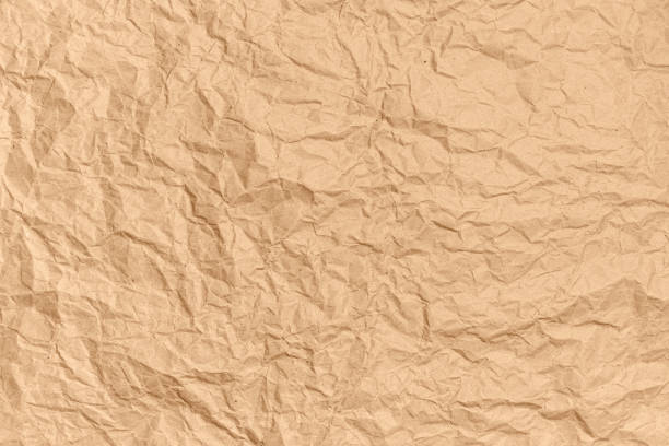 Crumpled brown kraft paper background. Abstract texture for design. Copy space for ad or announcement. Top view