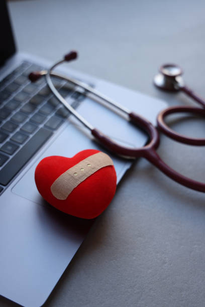 cuore rosso e stetoscopio sul computer portatile - help assistance computer computer keyboard foto e immagini stock