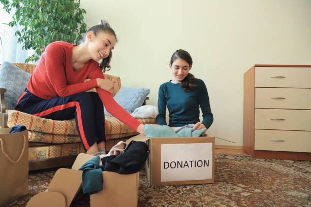 istock Two girls packing clothes for donation 1364935658