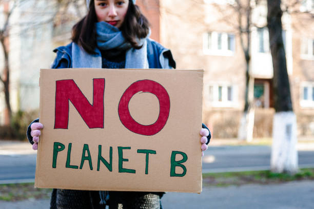 istock Young activist holding sign protesting against climate change 1364938303