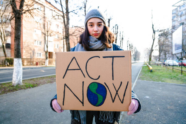 istock Young activist holding sign protesting against climate change 1364938318