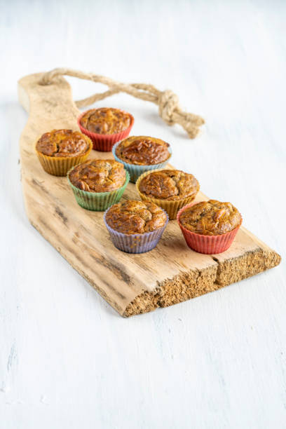Homemade muffin cakes in colorful molds on wooden table stock photo