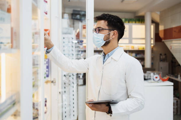 Young female pharmacist working in drugstore stock photo