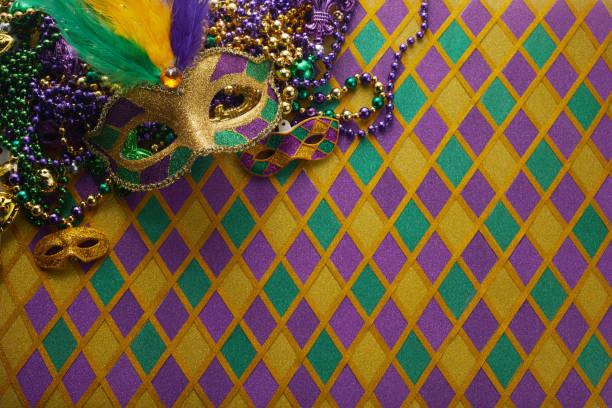 Frame of Mardi Gras Mask and colorful Mardi Gras Beads on diamond shaped background Frame of Mardi Gras Mask and colorful Mardi Gras Beads on diamond shaped background. purple and gold masquerade masks stock pictures, royalty-free photos & images