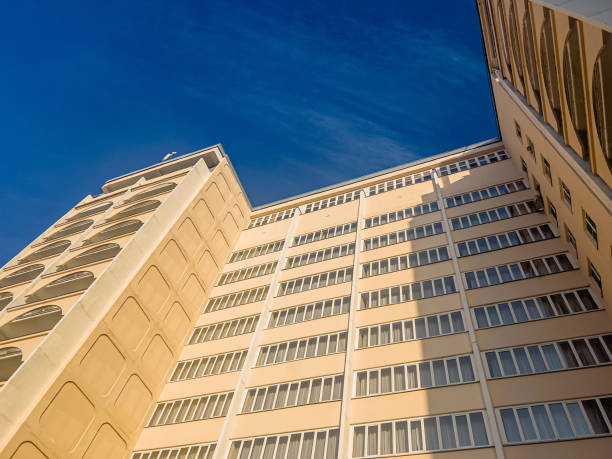 istock A beautiful yellow apartment building on a blue sky background. 1364943876