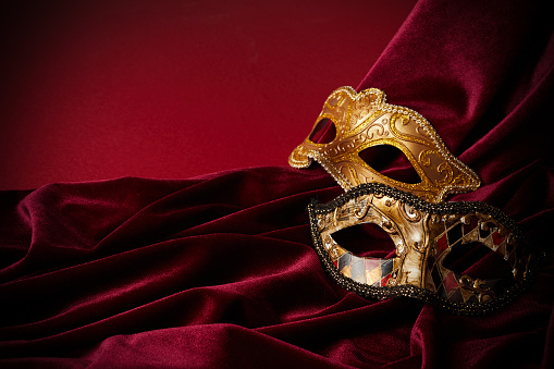 Luxury venetian mask on dark red background. Carnival masquerade fantasy mask.