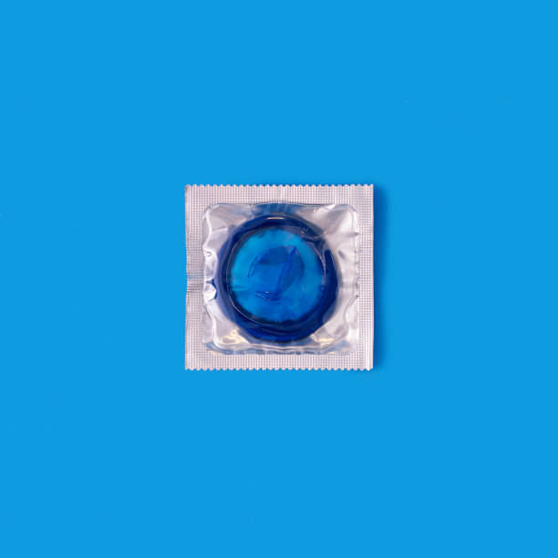istock Blue condom in transparent package against blue background 1364944000
