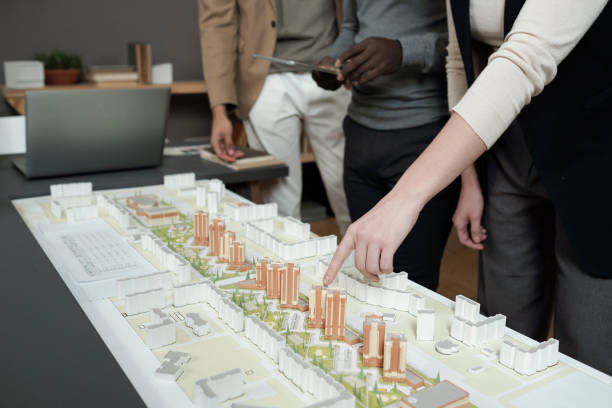 istock Hand of female architect pointing at layout during presentation 1364947182