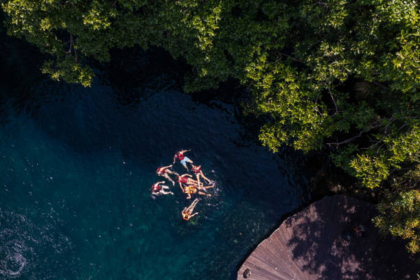Cenote with people in life jackets floating on a sunny day stock photo