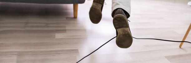 istock Man Legs Stumbling With An Electrical Cord 1364959066