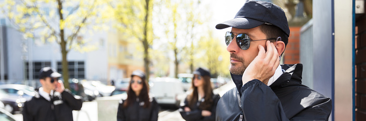 Close-up Of A Young Male Security Guard Listening With Earpiece