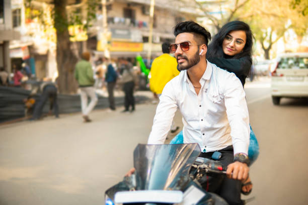 happy couple enjoying a motorbike rides on city road. - indian ethnicity audio imagens e fotografias de stock
