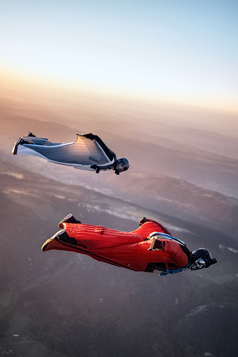 Los voladores wingsuit se elevan por encima del paisaje montañoso suizo photo