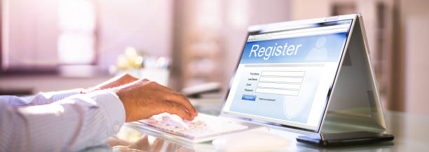 istock Businessman's Hand Filing Online Registration Form 1364962223