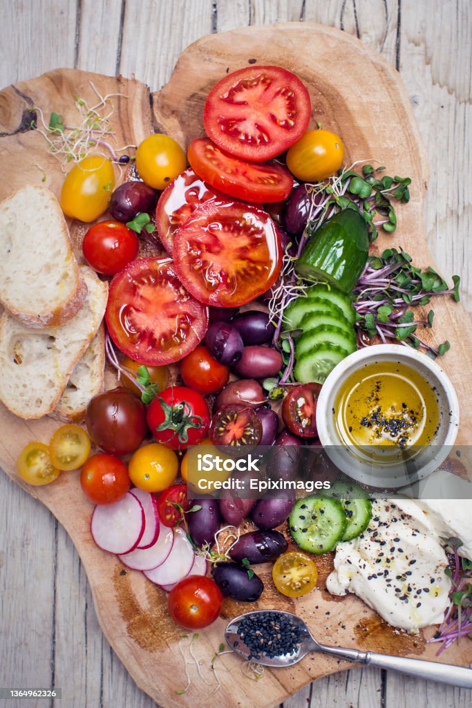healthy snack of olives, tomatoes, olive oil, bread and cucumber Healthy vegetarian snack with mozzarella cheese Mediterranean Food Stock Photo