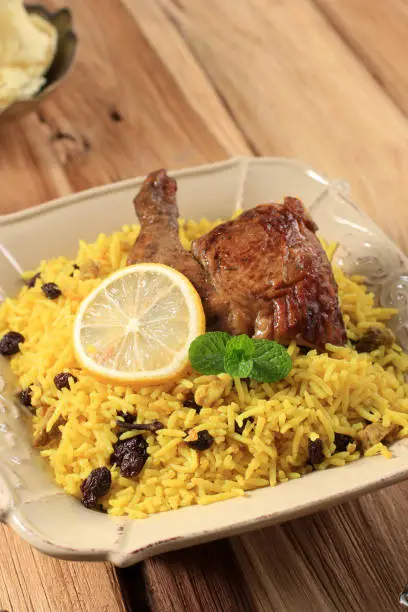 Delicious Spicy Chicken Biryani in Brown Plate Wooden Background, Indian or Pakistani Ramzan Food. Traditional Spicy Indian food, Iftar meal, Ramadan Dinner.