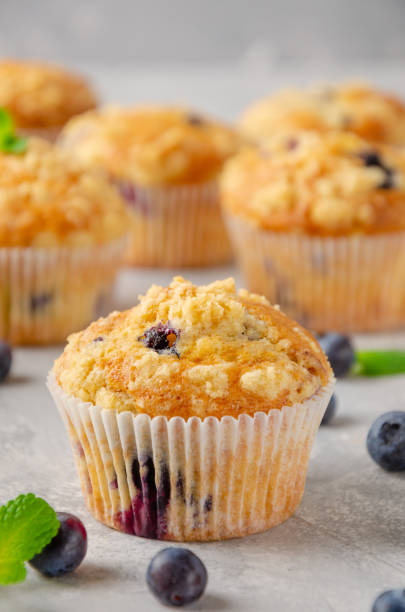 istock Lemon muffins with blueberries and shtreisel with fresh berries on a gray concrete background. Delicious breakfast. Copy space. 1364962895