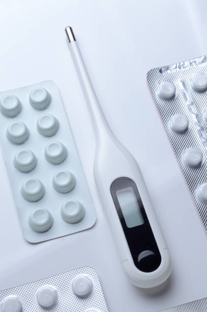 istock tablets in a package and a white electronic thermometer on a white surface close-up. 1364964051