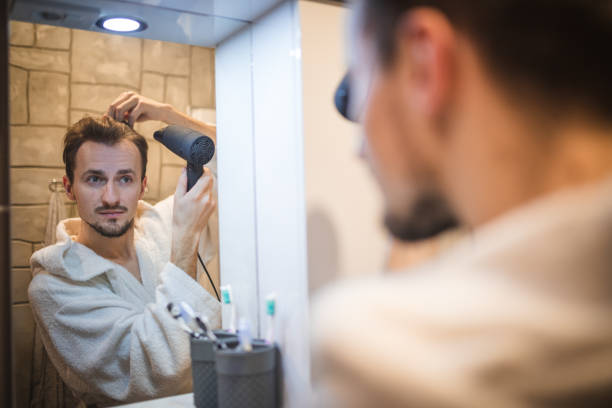 istock Handsome middle aged man drying his hair 1364968359