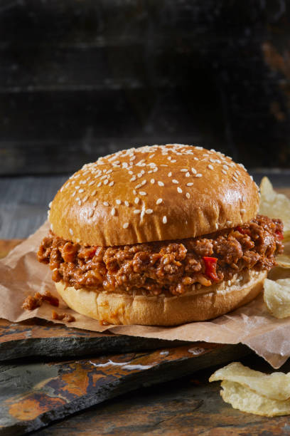 sloppy joe burger on a brioche sesame seed bun with potato chips - sesame bun american culture cheddar imagens e fotografias de stock