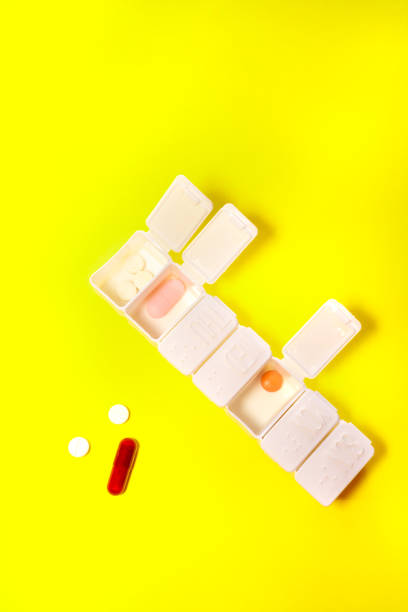 istock White weekly pillbox with different colorful pills isolate on yellow background with copy space. Medicines and medical concept. 1364973007