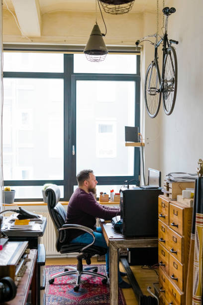 istock Mid adult man working on computer at his home office 1364974007