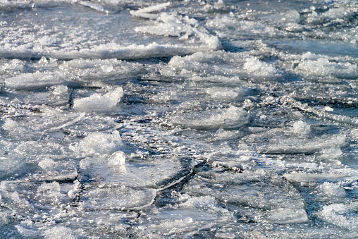 Closeup of Lake freezing over. Large patches of frozen water.
