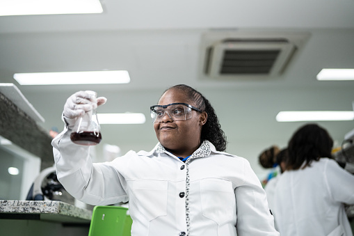 Young woman with special needs holding a conical flask in the laboratory