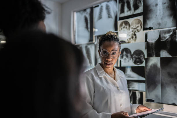 istock Teacher holding a digital tablet and explaining about Xrays to students 1364980273
