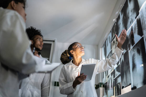 Teacher holding a digital tablet and explaining about Xrays to students Teacher holding a digital tablet and explaining about Xrays to students examining x ray stock pictures, royalty-free photos & images