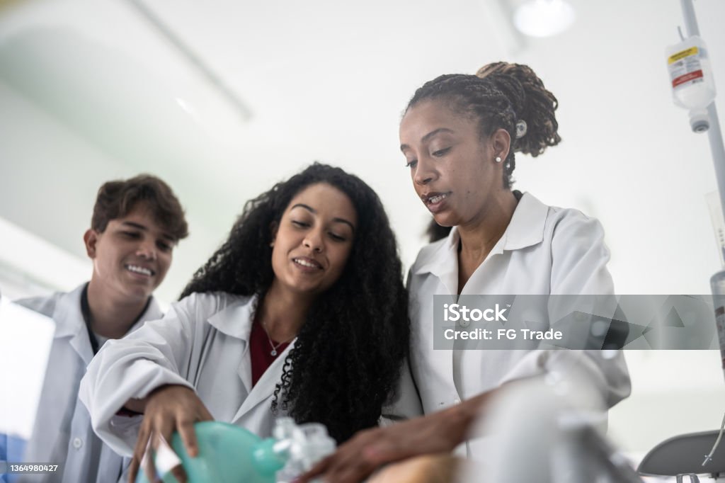 Teacher explaining how to do a medical procedure in the classroom Student Stock Photo