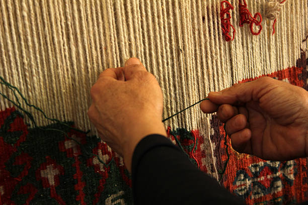 Person hand weaving rug on loom  stock photo