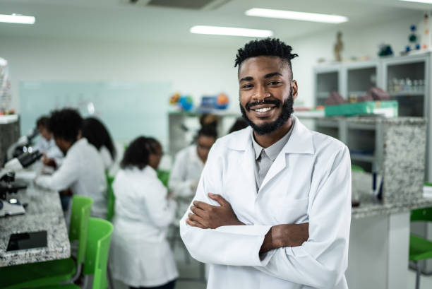 ritratto di uno studente felice in laboratorio - laboratory scientist african ethnicity science foto e immagini stock