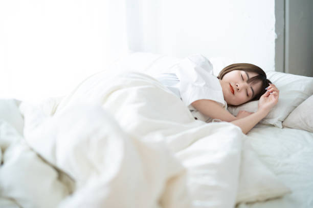 Female sleeping on a bed Female sleeping on a bed in a bright room only women women bedroom bed stock pictures, royalty-free photos & images