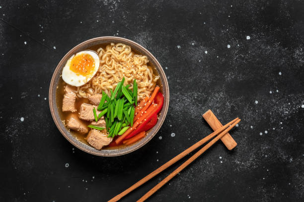 istock Ramen noodle soup with chicken, vegetables and eggs. Black rustic stone background. Top view. Japanese food. 1364983931