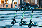 rental electric kick scooter parked at city street