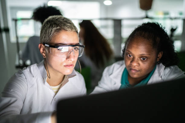 Students using laptop in the lab - including person with special needs Students using laptop in the lab - including person with special needs high school high school student science multi ethnic group stock pictures, royalty-free photos & images