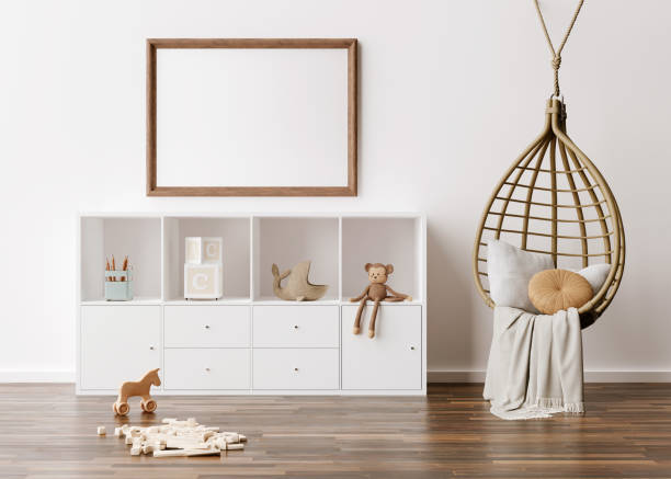 istock Empty picture frame on white wall in modern child room. Mock up interior in scandinavian, boho style. Free, copy space for your picture. Console, rattan armchair, toys. Cozy room for kids 3D rendering 1364986065
